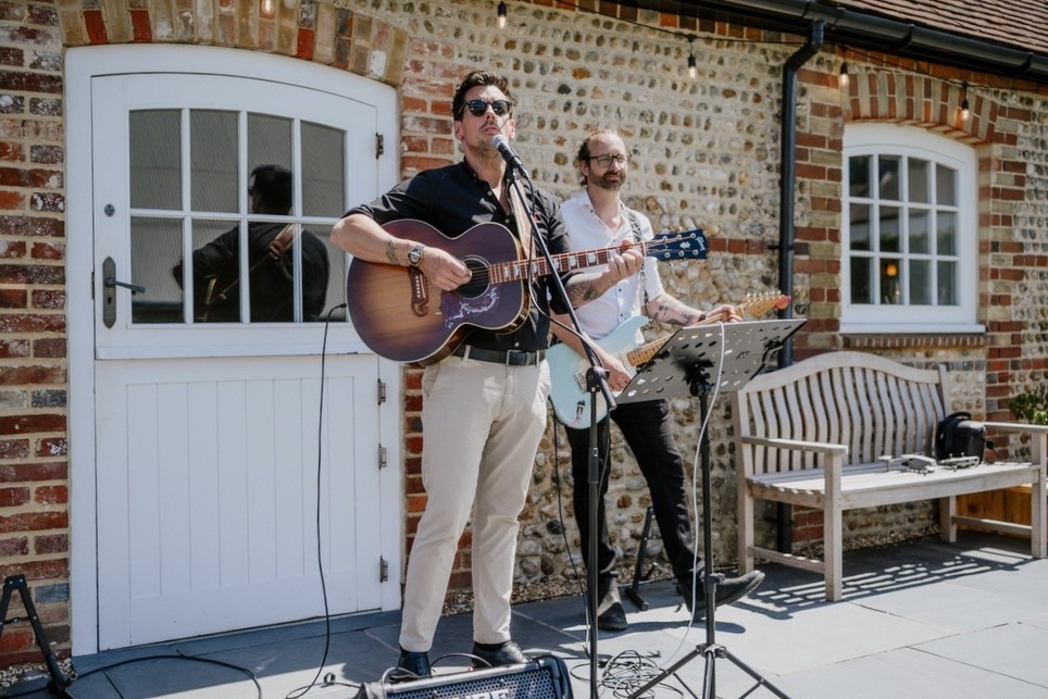Matt and guitarist performing outdoors at a drinks reception